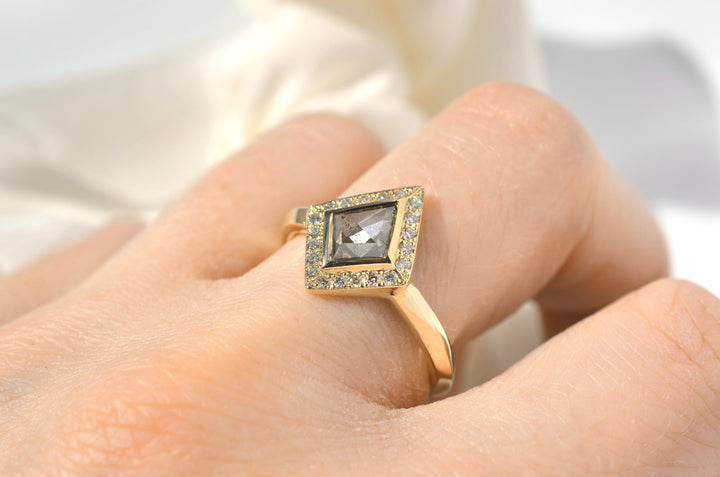 Modeled photo of angular halo engagement ring on woman's hand with white background. Kite shaped champagne diamond ring.