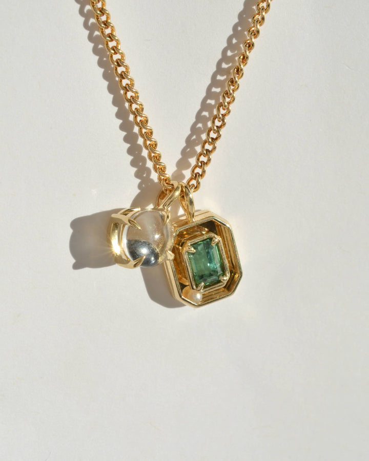 the green tourmaline orbit charm, and 14K googly eye charm from Emma Brooke jewelry, styled on a chain