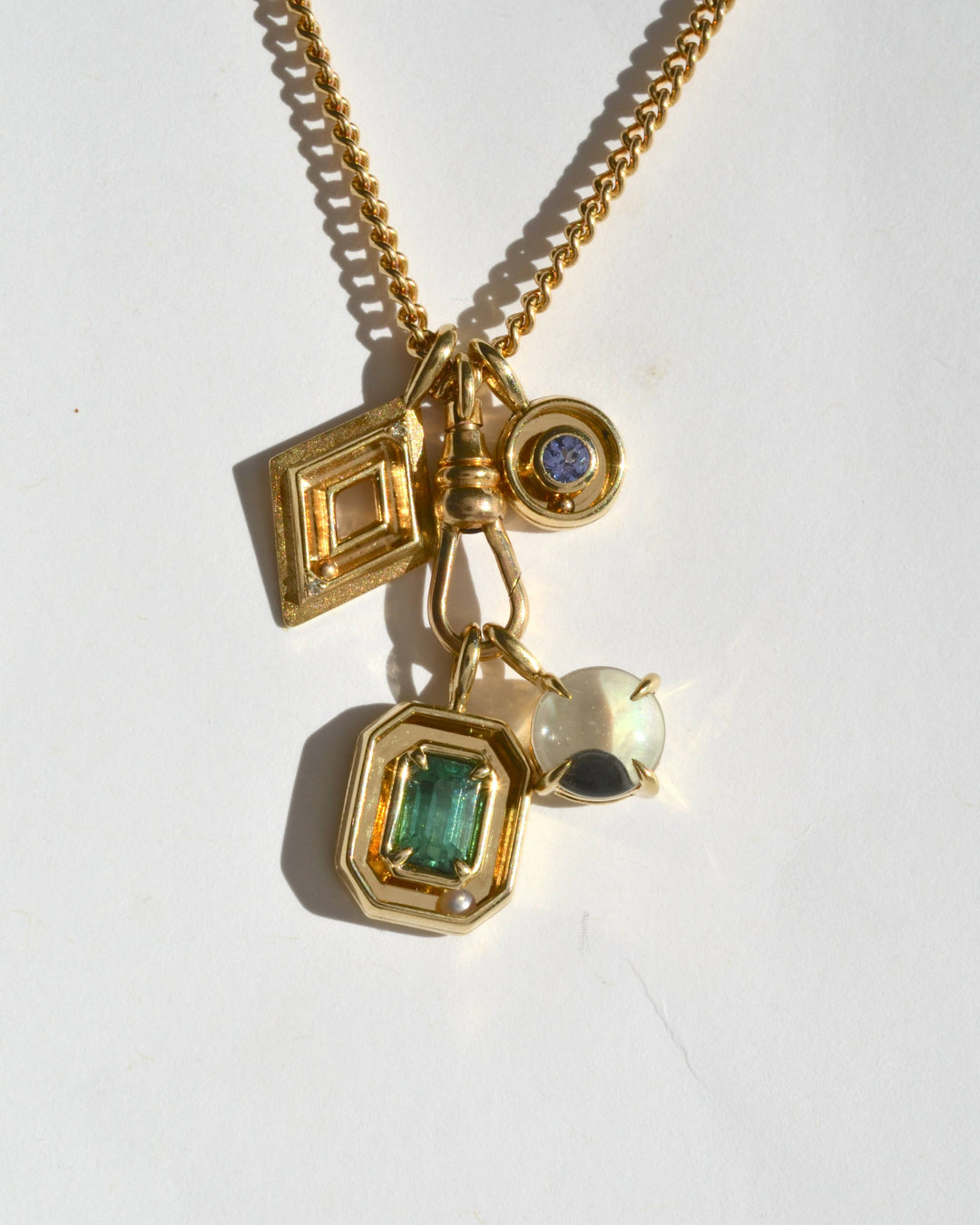 a jumble of gold, kinetic jewelry charms hanging from a chain.