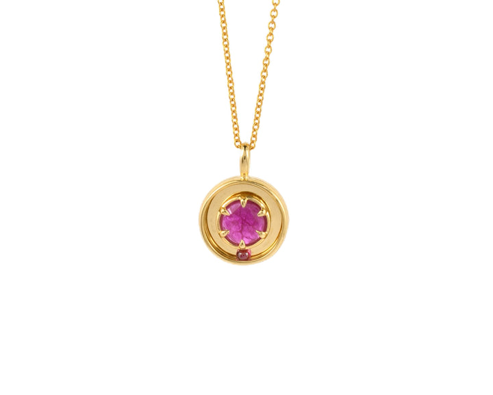 pink ruby and yellow gold pendant by Emma Brooke jewelry, with a rolling ruby ball.
