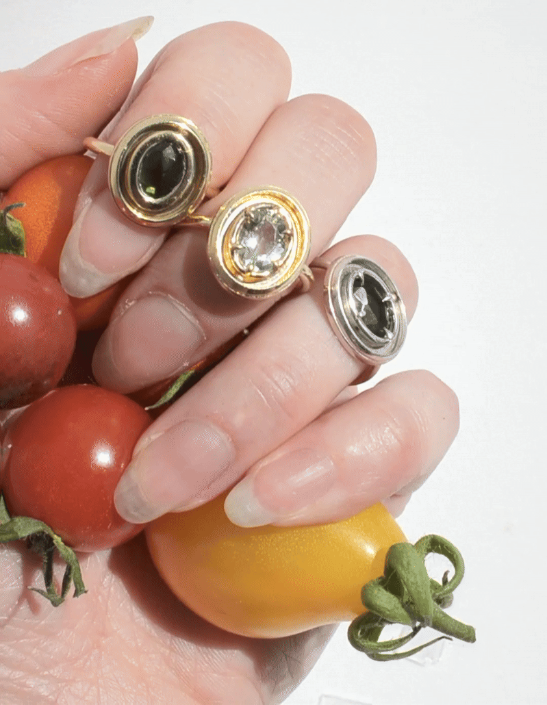 gif of orbit rings in motion, modeled on a fistful of colorful tomatoes